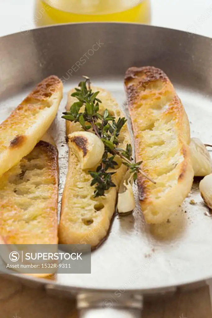 Slices of toasted white bread with garlic and thyme