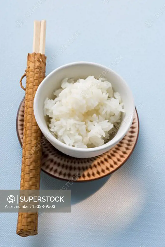 Bowl of rice and chopsticks on plate