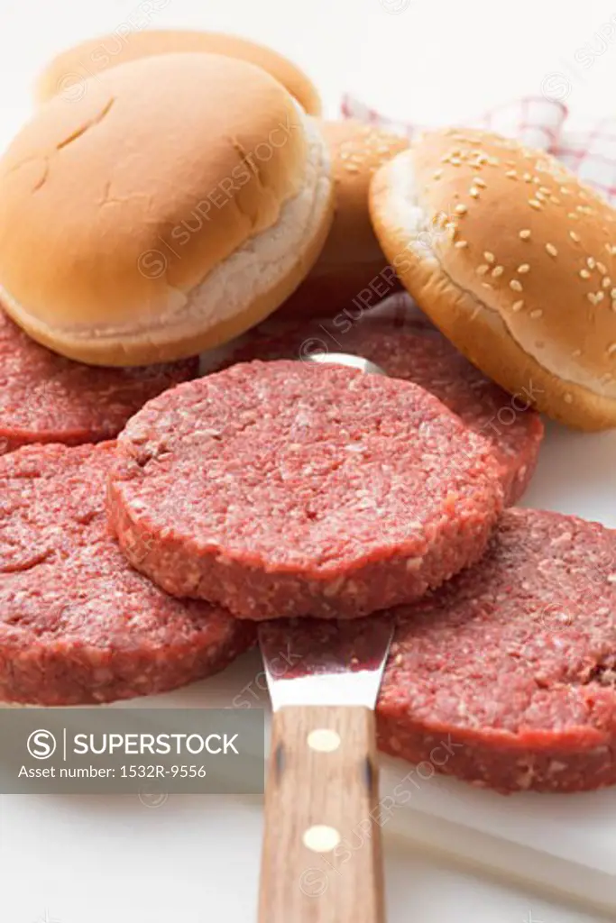 Raw burgers and hamburger rolls