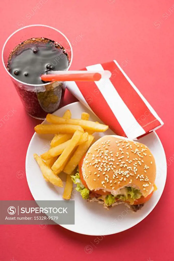 Cheeseburger, bites taken, with chips and Cola