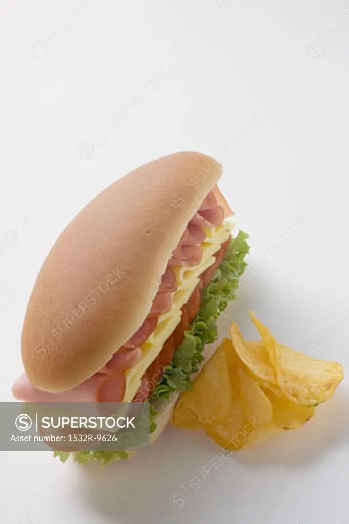 Ham, cheese, tomato and lettuce sandwich with crisps