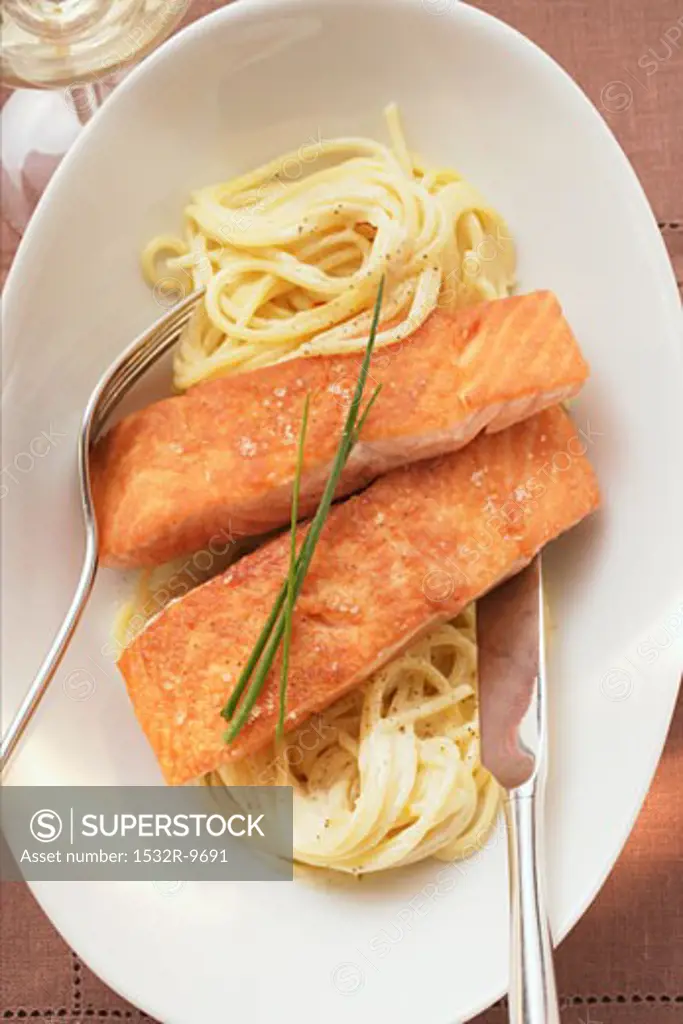Fried salmon fillets on spaghetti