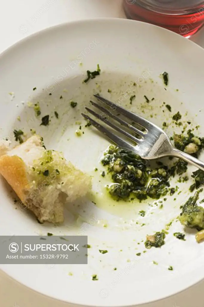Remains of pesto and white bread on plate