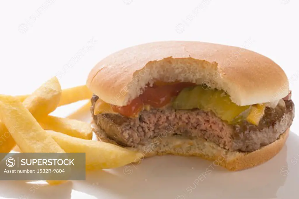 Cheeseburger (with a bite taken) with chips