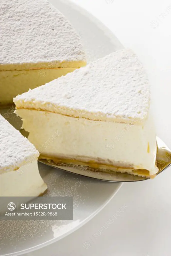 Cream cheesecake, a piece cut, with piece on server