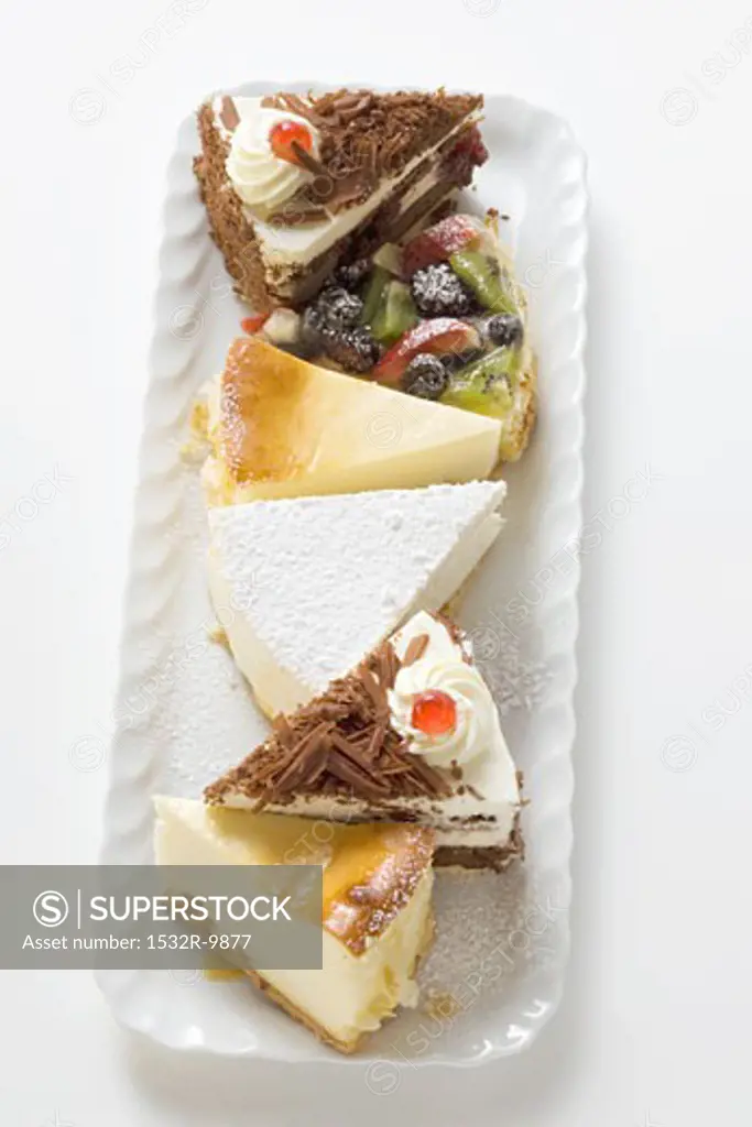A selection of pieces of cake on white plate