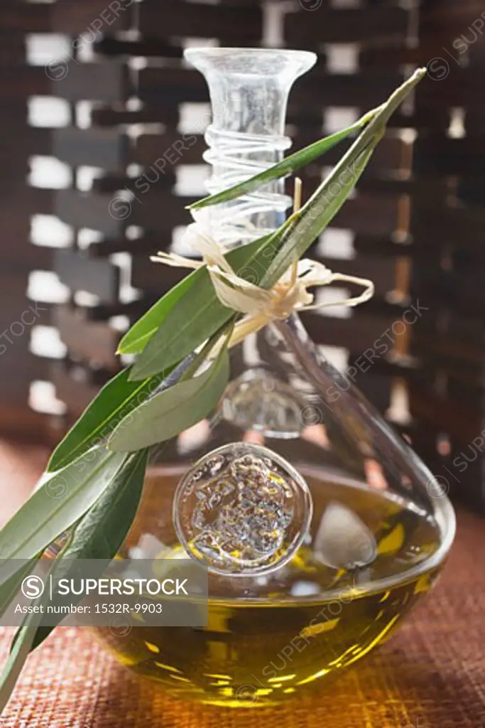 Olive oil in carafe with olive branch