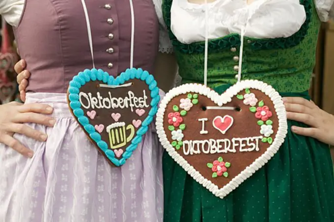Two women in national dress with Lebkuchen hearts at Oktoberfest