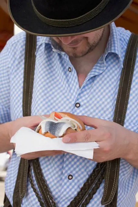 Man eating herring roll at Oktoberfest