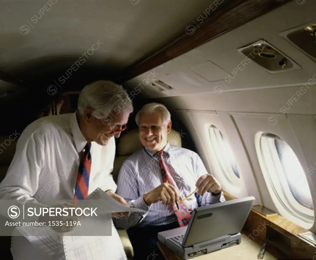 Two businessmen traveling on an airplane