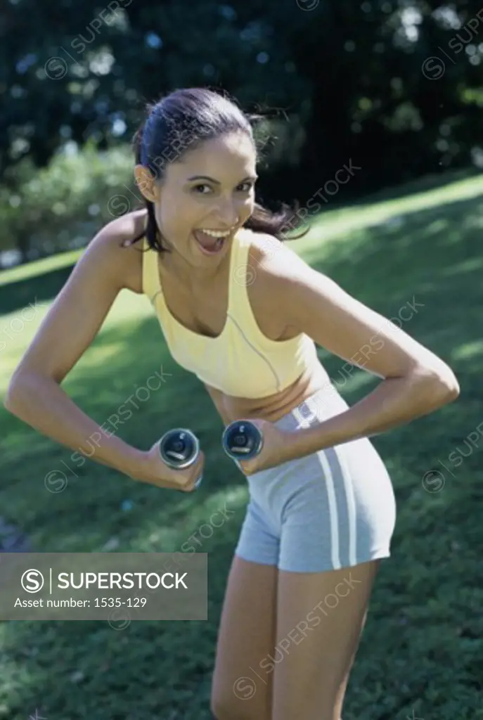 Portrait of a teenage girl exercising with dumbbells