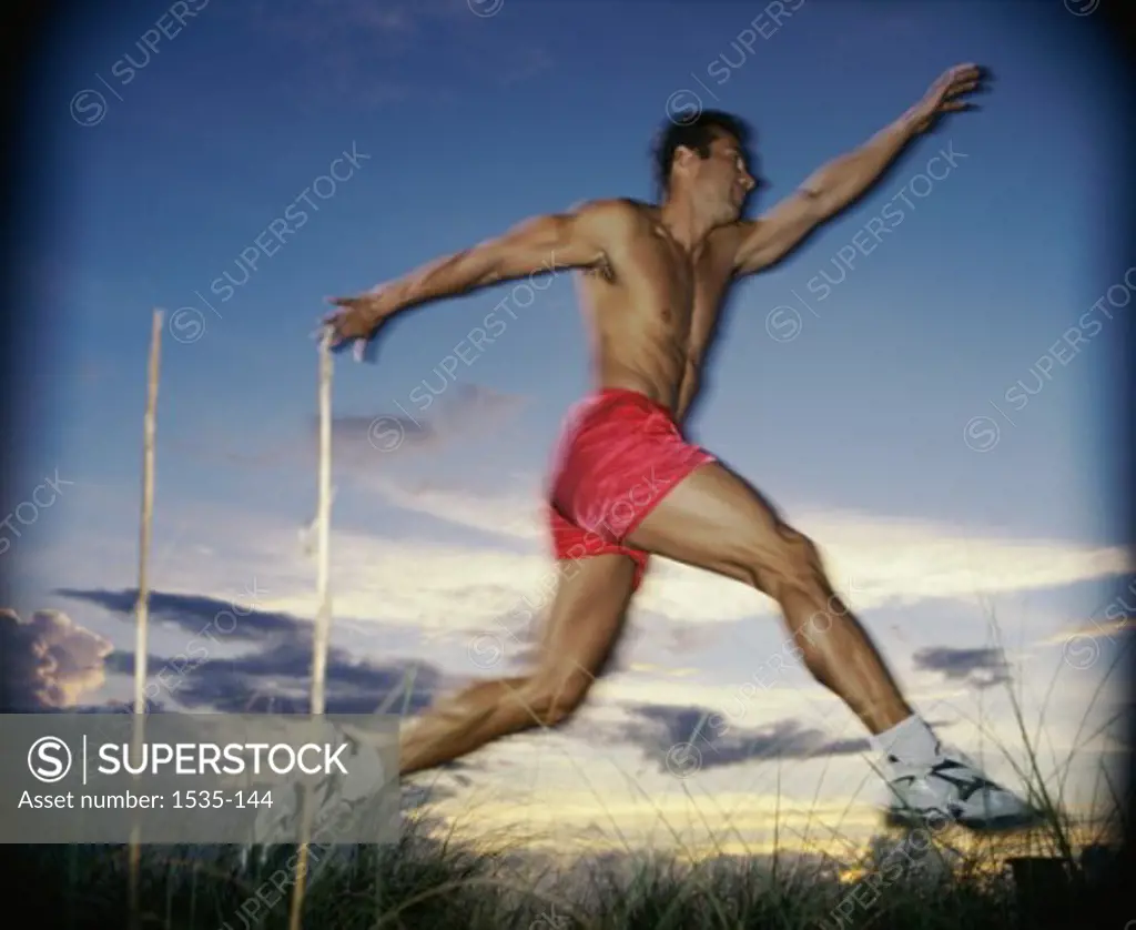 Side profile of a young man leaping