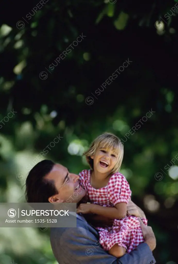 Side profile of a father carrying his daughter