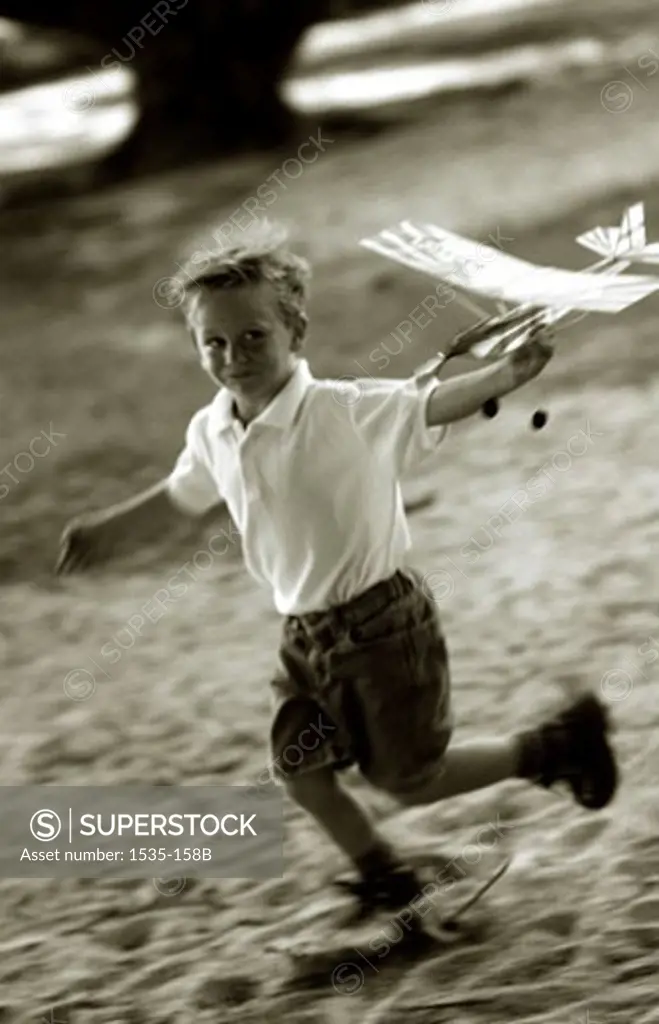 Boy running with a toy airplane