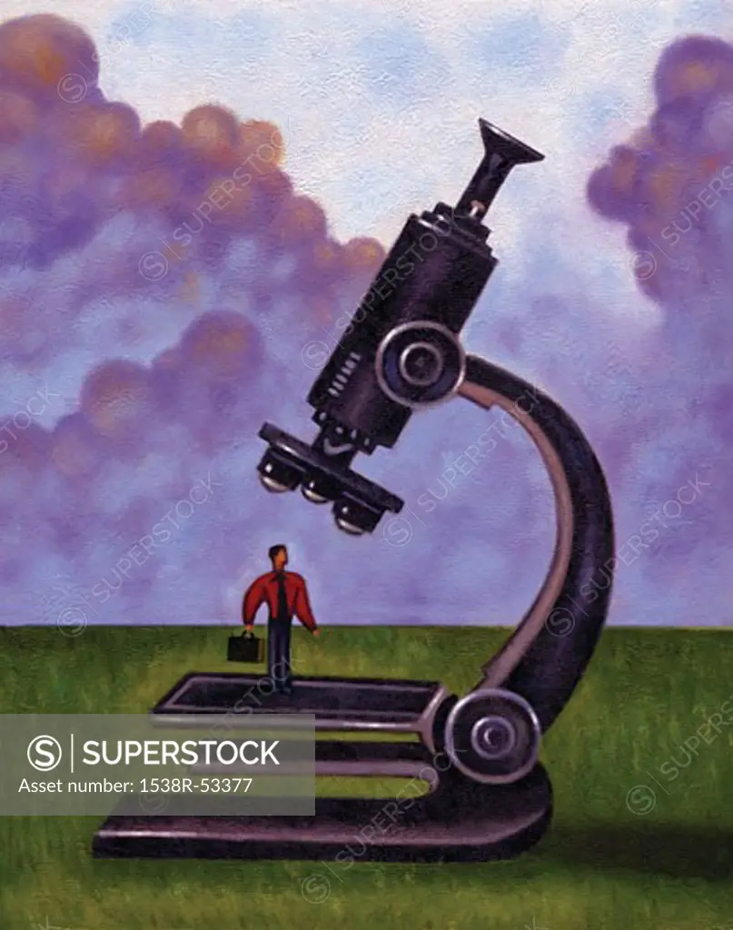 Businessman standing underneath a microscope