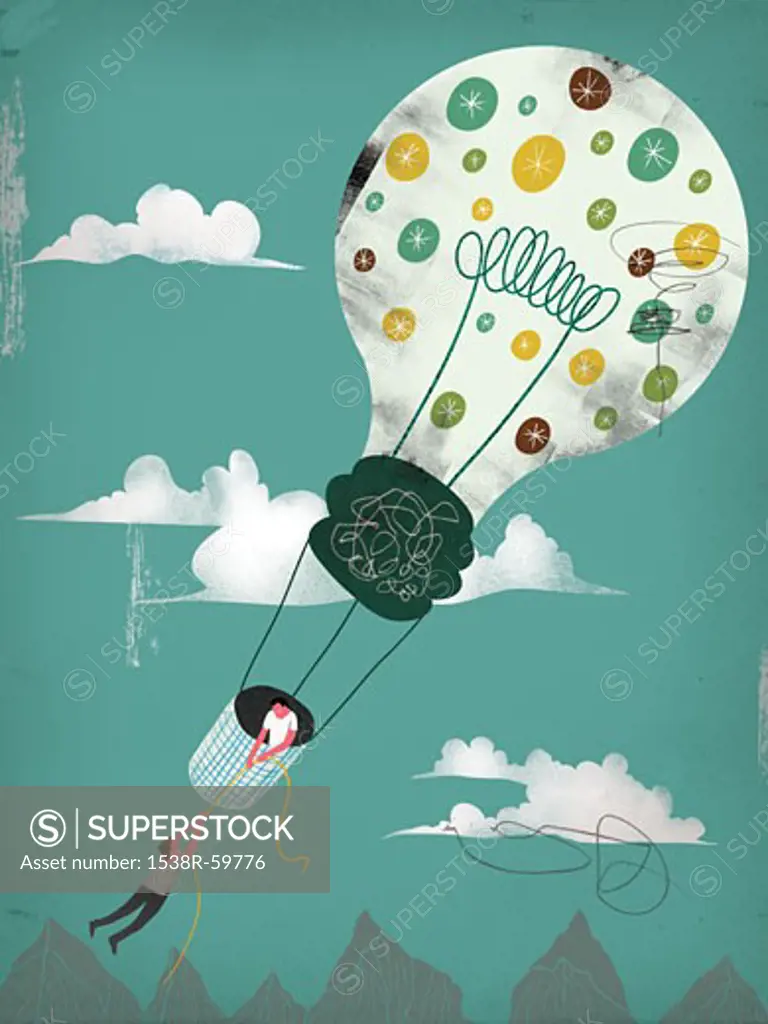 A man hanging off a rope held by another man in a lightbulb shaped hot air balloon