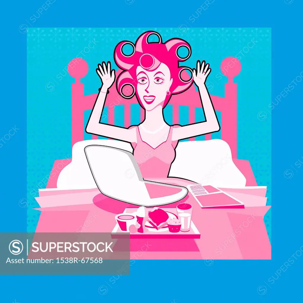 A woman with her hair set in rollers in bed working on a laptop computer