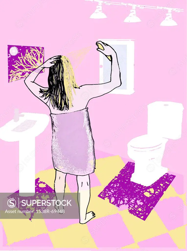 A woman wearing a towel in the bathroom while spraying her hair