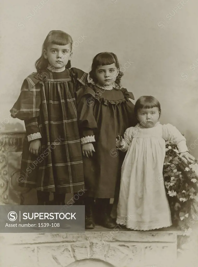 Portrait of three girls standing together, c. 1885