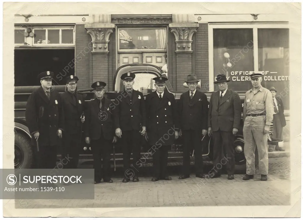 Portrait of police officers standing in front of a car, 1928