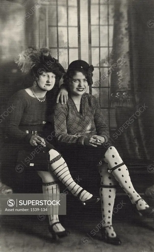 Portrait of two young women holding cigarettes