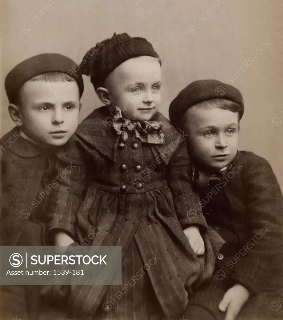 Close-up of two boys sitting with their sister, c. 1880