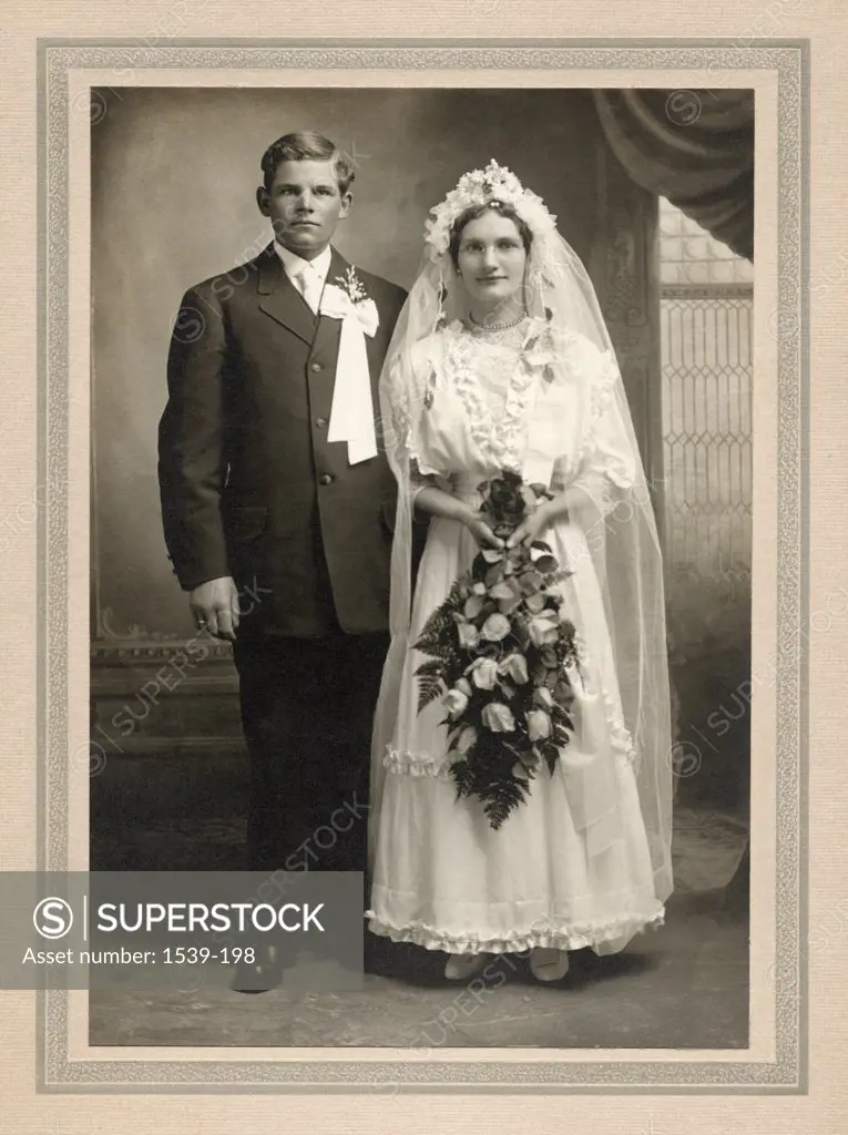 Portrait of newlywed couple standing with a bouquet of flowers, Wayne, Nebraska, USA, 1915