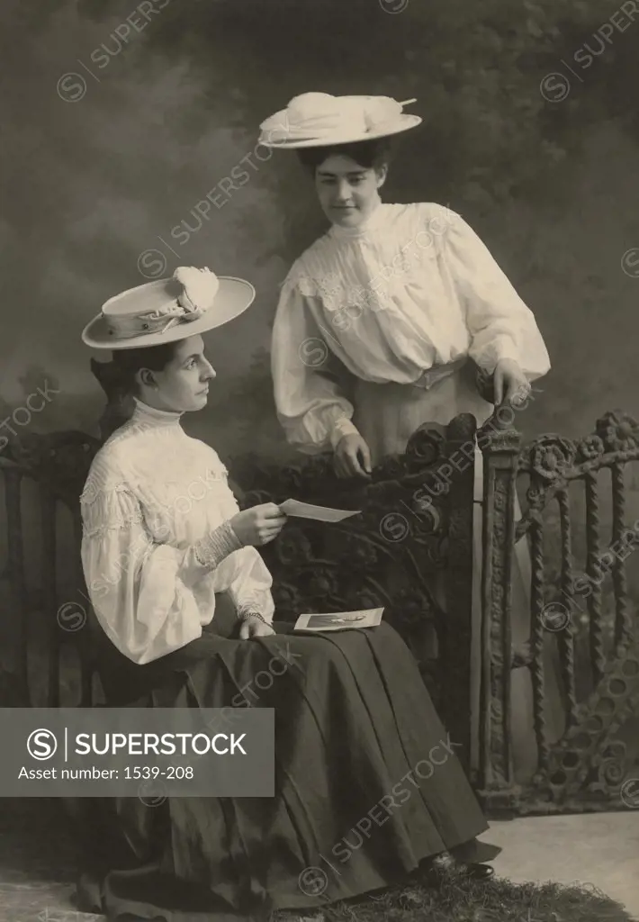 Two young women looking at a photograph, Minneapolis, Minnesota, USA, 1895