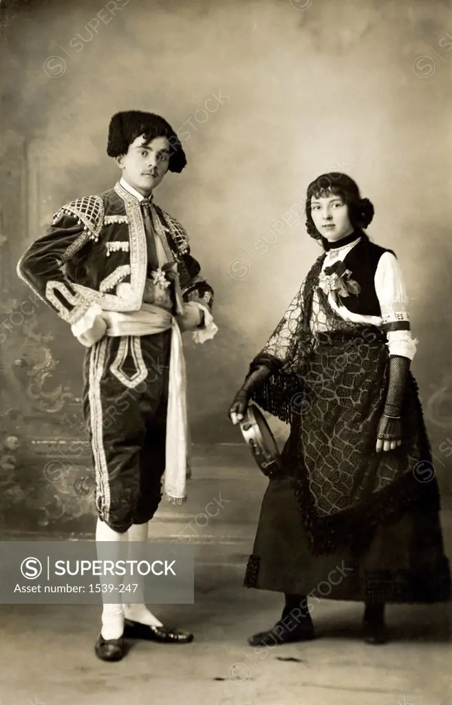 Young couple standing in traditional Spanish costumes, c.1910