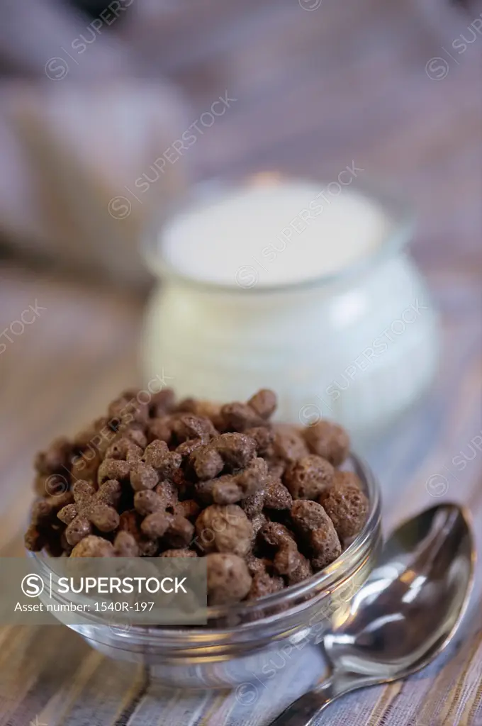 Close-up of breakfast cereal in a bowl near a jar of milk