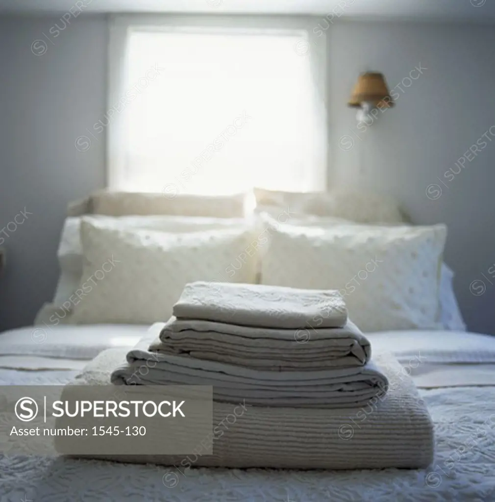 Close-up of a stack of blankets on the bed