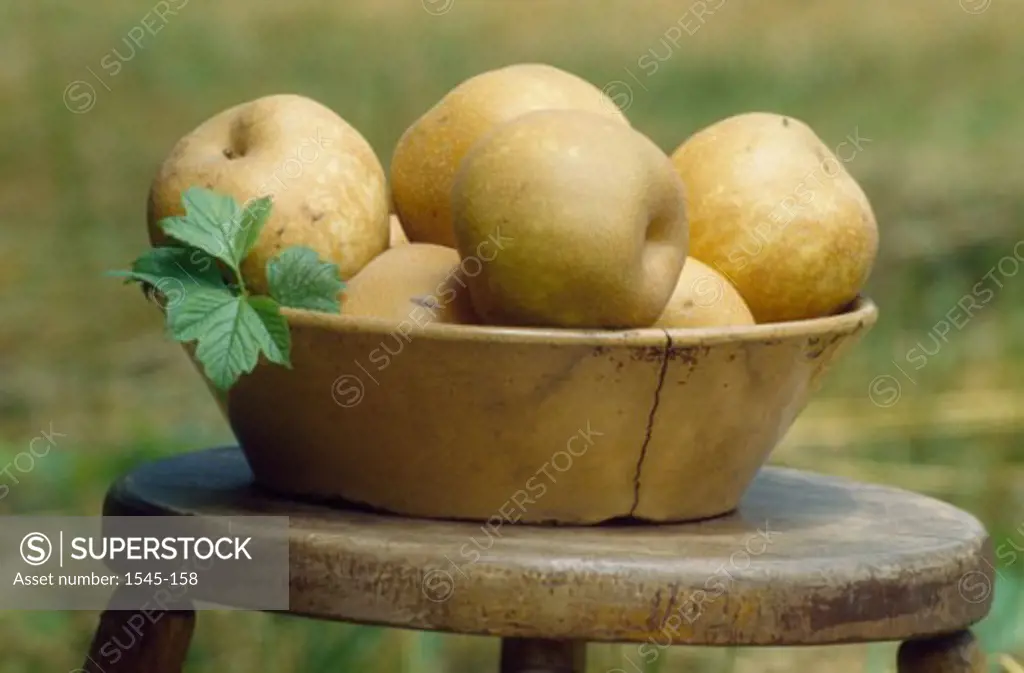 Close-up of pears in a bowl on a stool