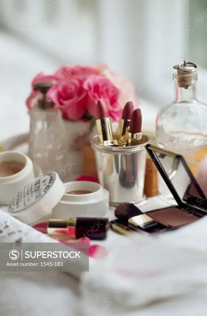 Close-up of face powder boxes with make-up brushes and a mirror on a tray