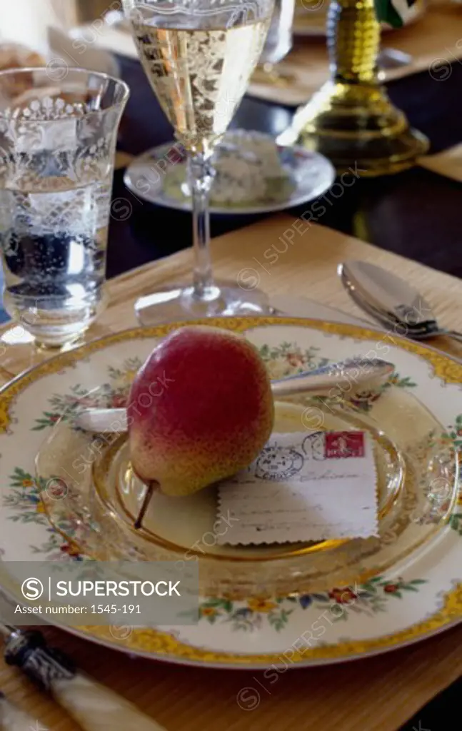 Close-up of a pear and a bill on a plate