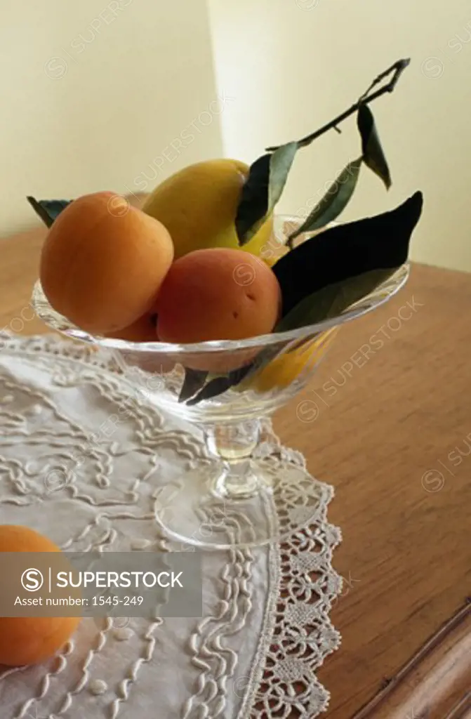 Close-up of peaches and a pear in a bowl on a table