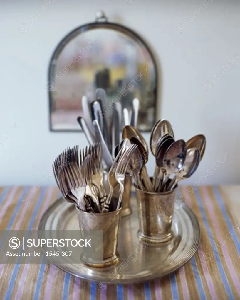 Close-up of forks with spoons in glasses