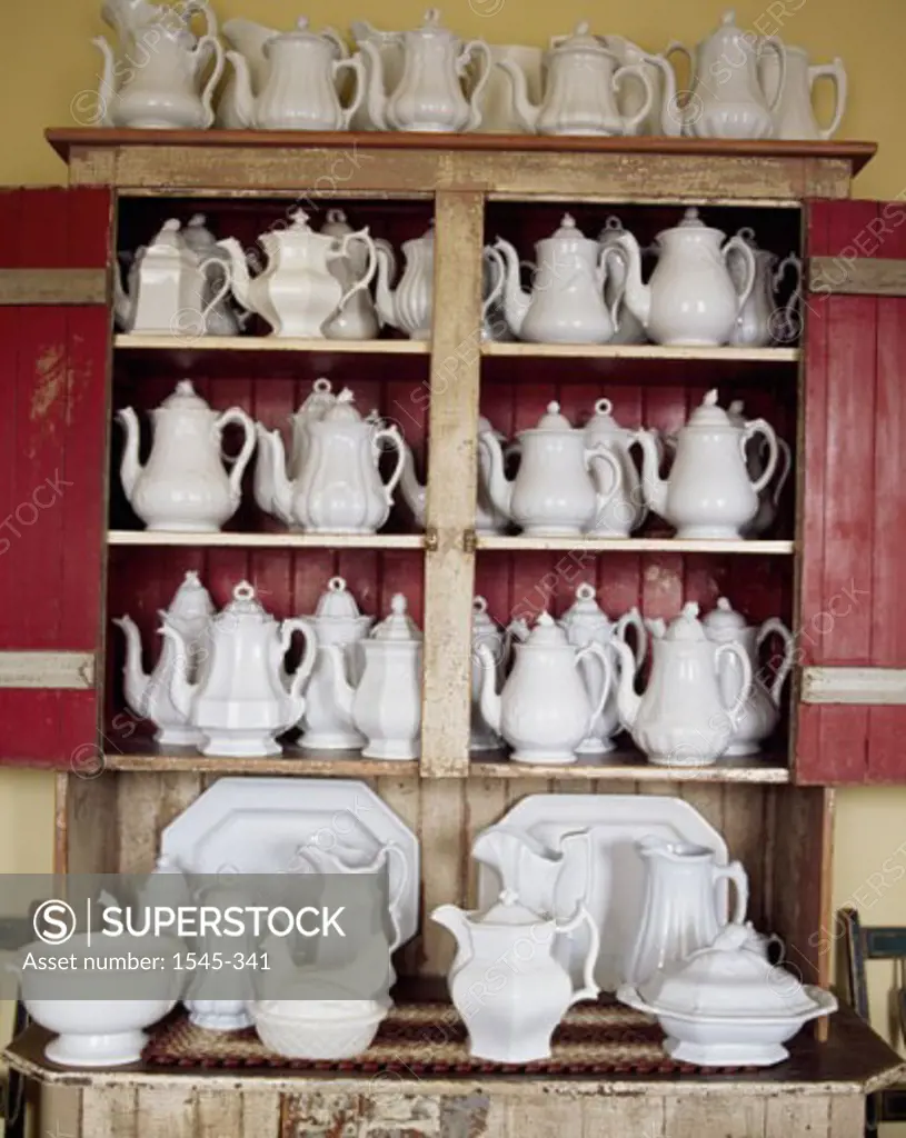Teapots on a shelf in a kitchen
