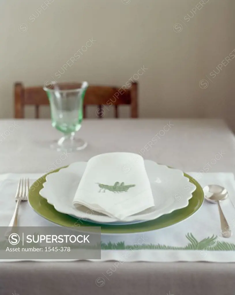 Close-up of a napkin with a plate and fork on a table