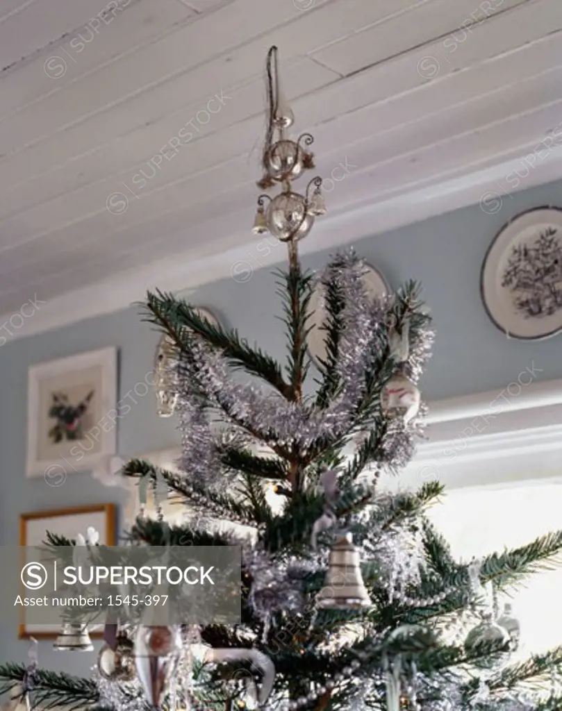 Close-up of a decorated Christmas tree hanging from a ceiling