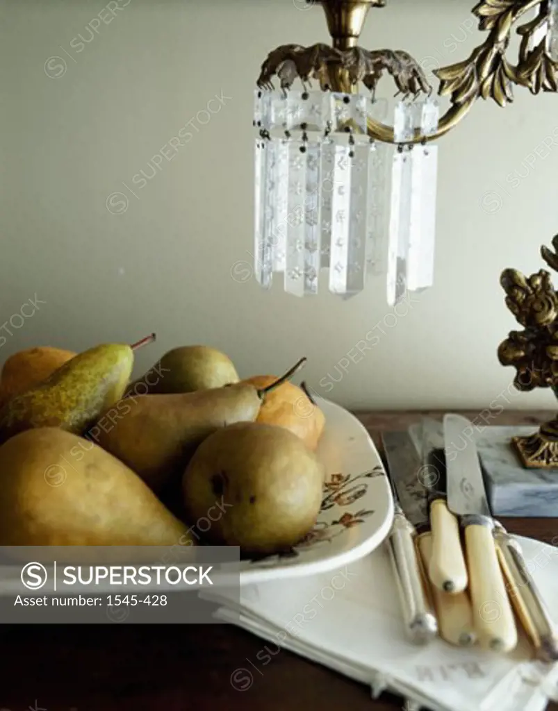 Close-up of pears with knives on a table