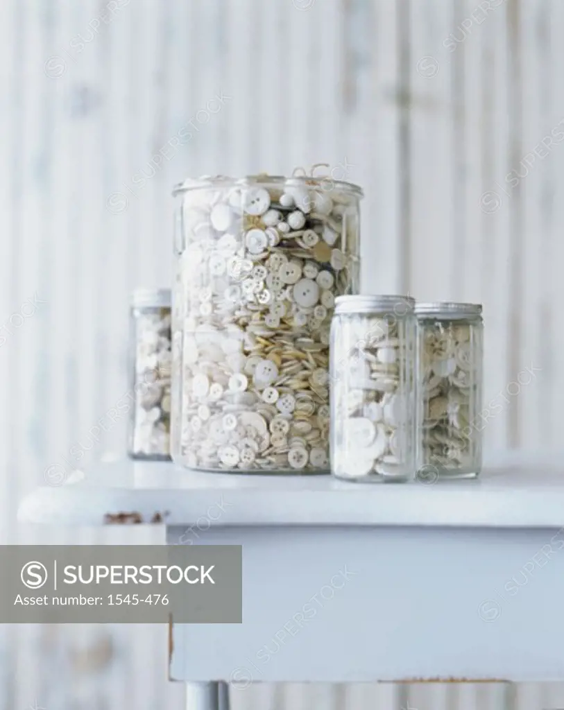 Close-up of buttons in jars on a table