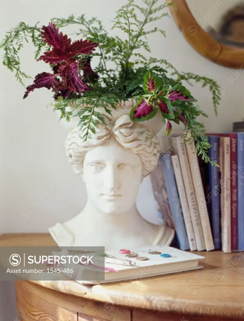 Flowers in a vase with books on a desk