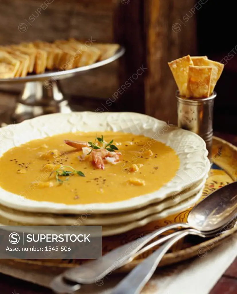 Close-up of soup in a bowl on a table with crackers