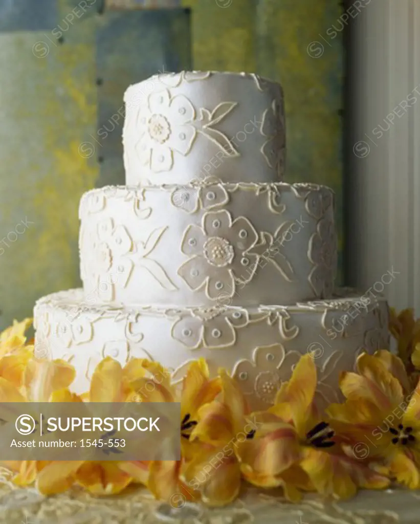 Close-up of a wedding cake with flowers around it