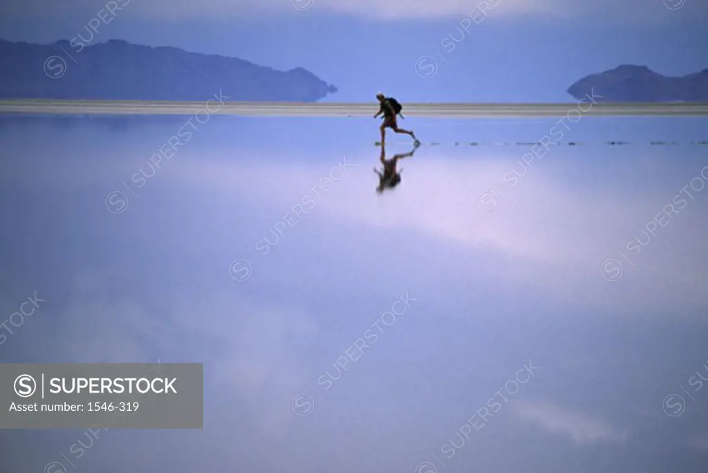 Side profile of a hiker running on water, Bonneville Salt Flats, Utah, USA