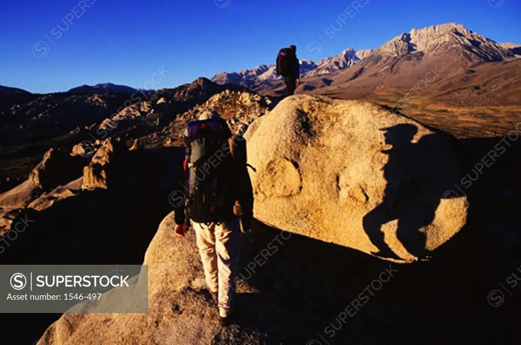 Rear view of a couple hiking on a mountain, The Buttermilks, California, USA