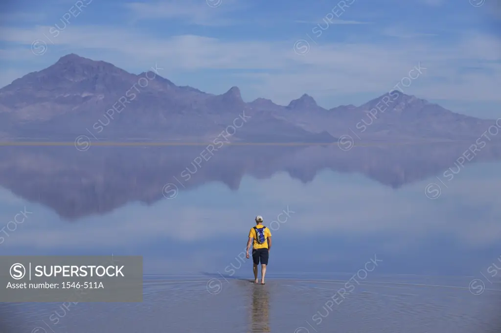 Rear view of a man walking across a salt flat, Bonneville Salt Flats, Utah, USA