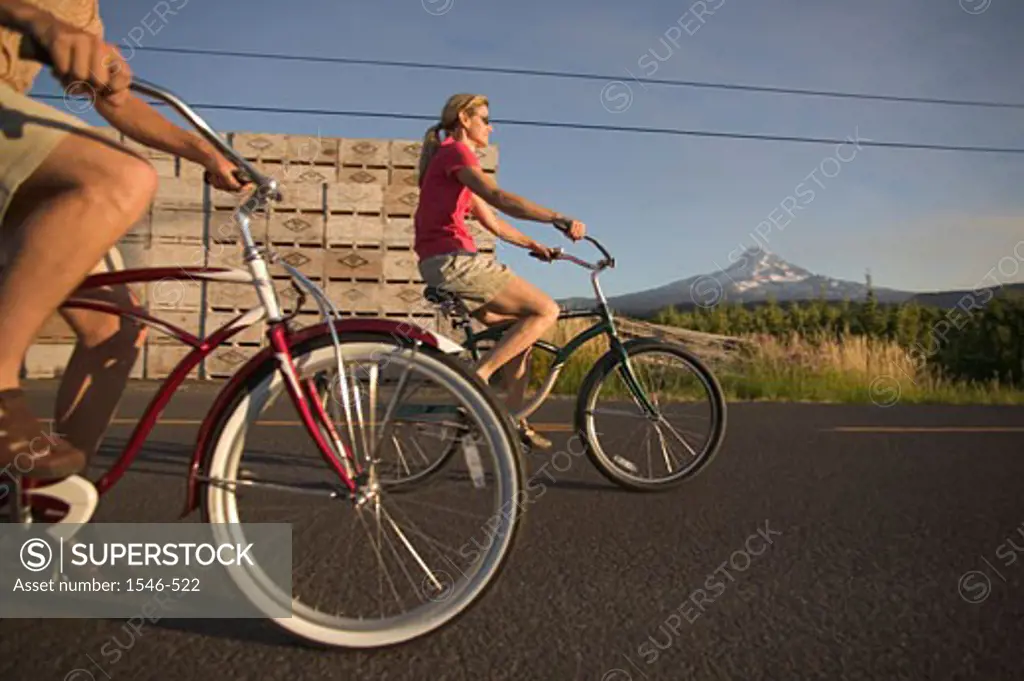 Low section view of a man and a woman riding bicycles on a road