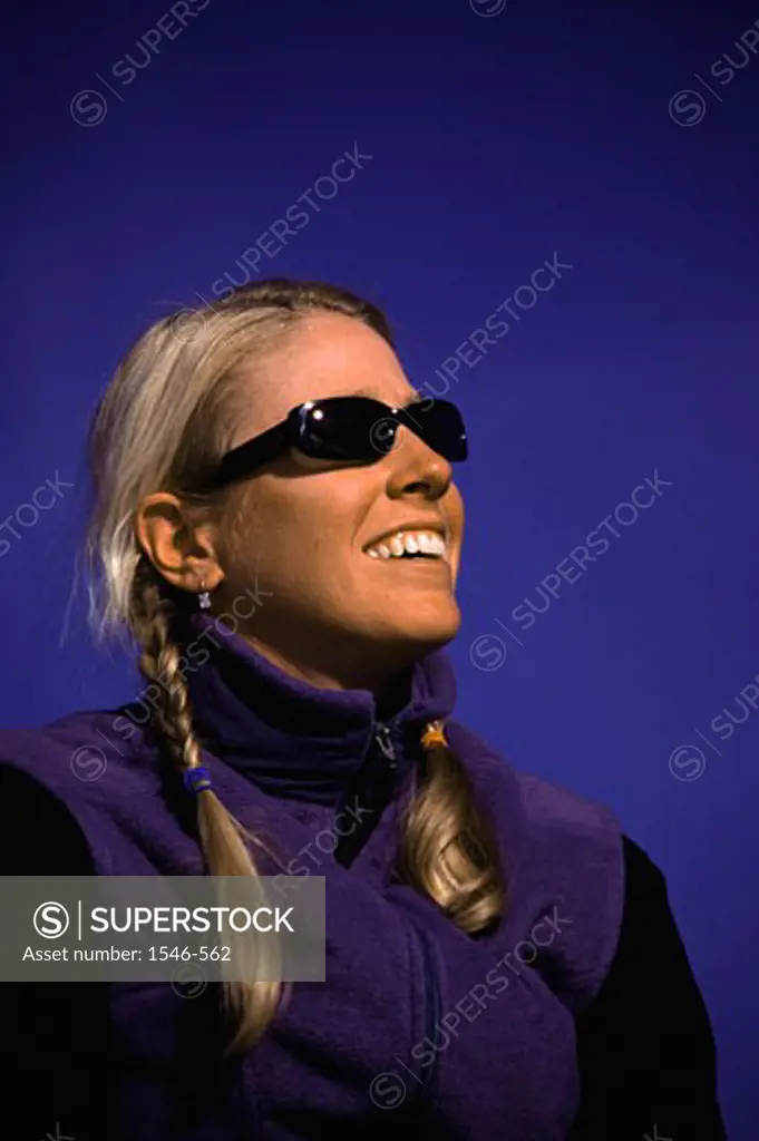 Close-up of a young woman smiling and wearing sunglasses