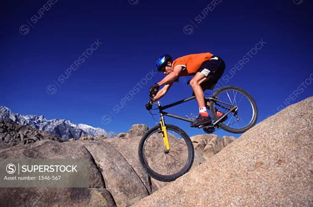 Low angle view of a man riding a mountain bike on a hill